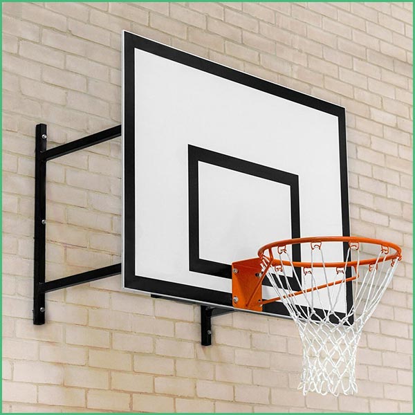 Basketball hoop mounted to a beige brick wall, featuring a white backboard with a black frame and an orange rim with a white net 