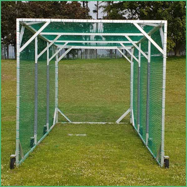 Green metal frame practice netting tunnel on a grassy field, open ends facing away