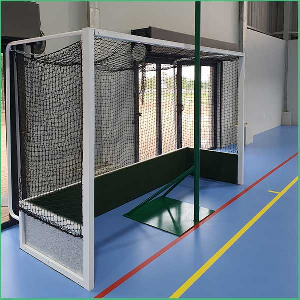 Indoor sports practice goal with white frame, black netting, and green protective panels on the sides, set on a blue gym floor with court lines